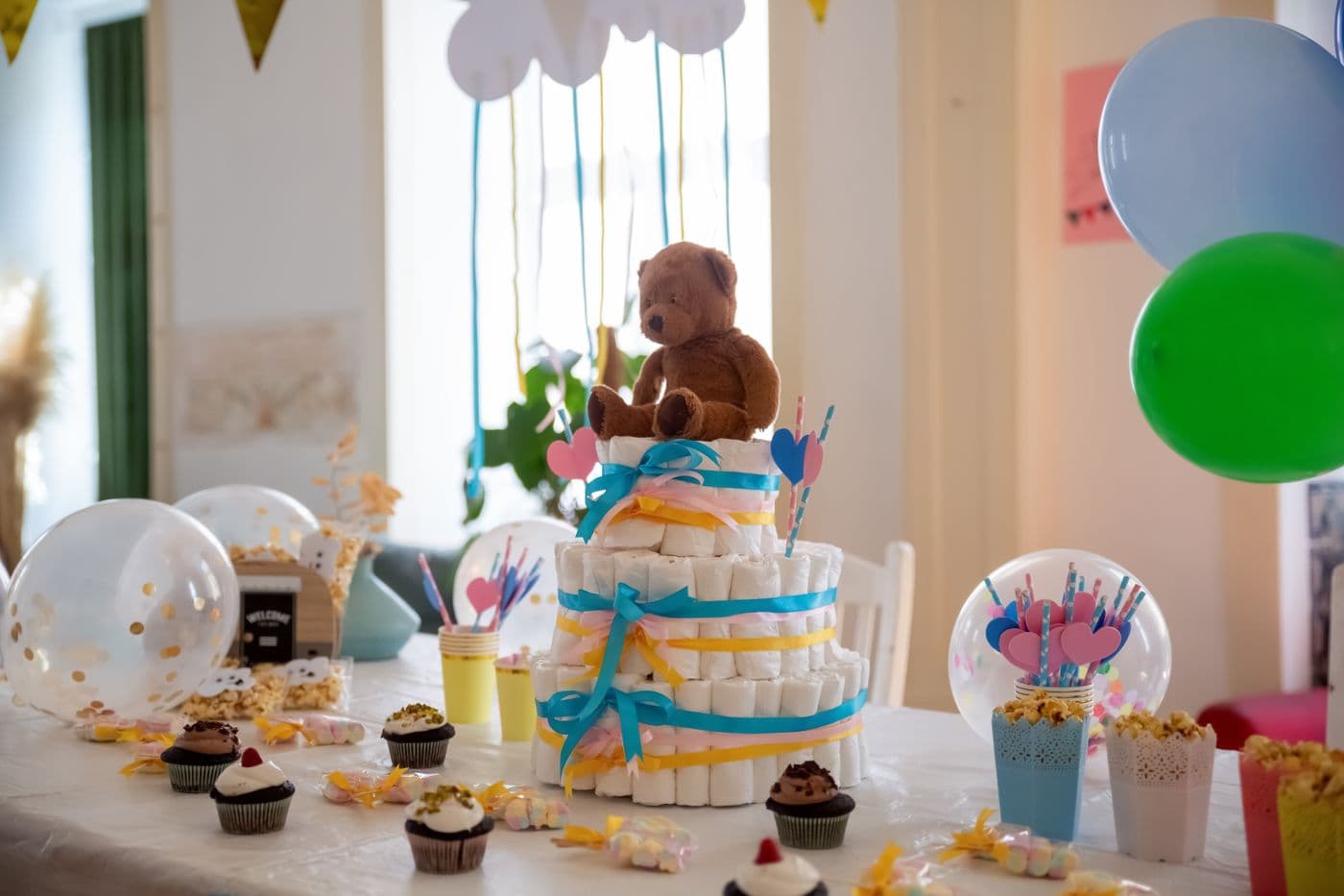 Mesa de baby shower con torta, globos y regalos